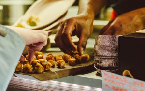 Two people eat off of a pu-pu platter.